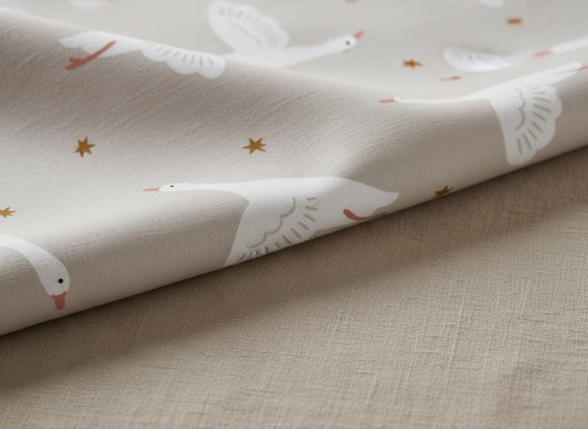 A light beige fabric featuring a repeating pattern of white geese in flight with orange beaks and feet, interspersed with small, dark orange four-pointed stars. The textile has a visible woven texture and is folded over itself.