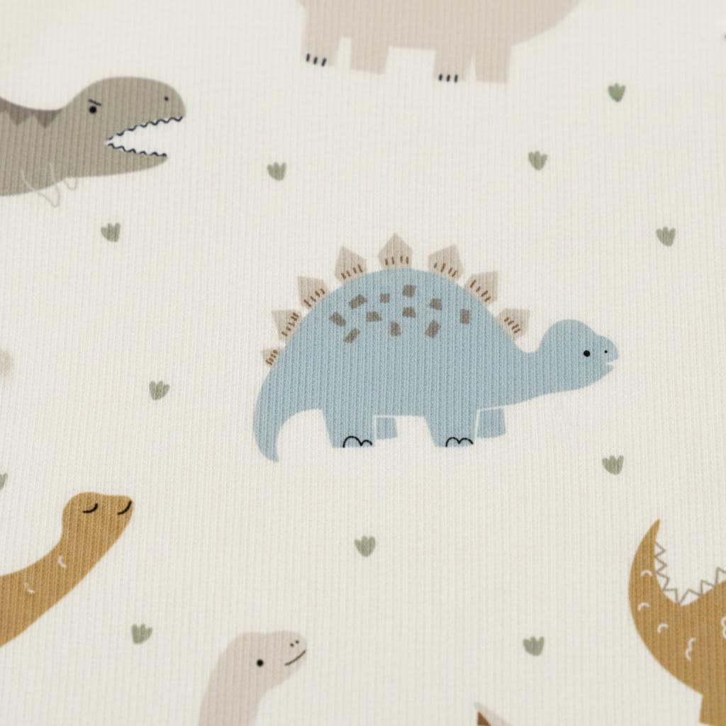 Close-up of textured fabric printed with the Boho Dinosaur pattern, showing a blue stegosaurus and caramel long-neck dinosaurs.
