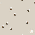 A light beige fabric featuring a repeating pattern of small, stylised bees with brown and black striped bodies and white wings. In the bottom right corner, there is a small white circular logo containing the lowercase letter b.