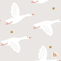 A repeating pattern on a light beige background featuring white geese in flight with orange beaks and feet, interspersed with small gold stars. A small circular logo with the letter b and a pink dot appears in the bottom right corner.