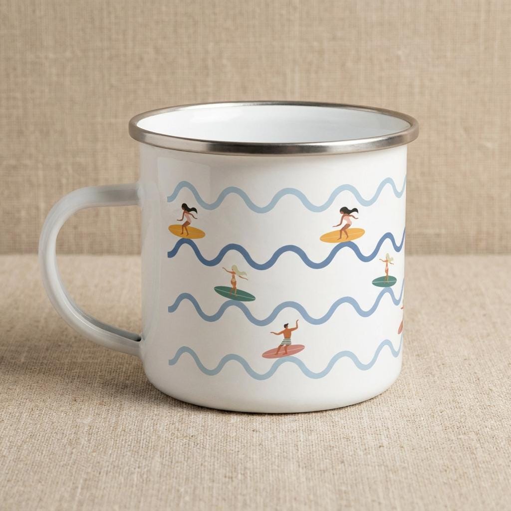 A white enamel mug with a silver-toned rim and handle, featuring a repeating pattern of light blue and dark blue wavy horizontal lines interspersed with small illustrations of people surfing on colourful surfboards.
