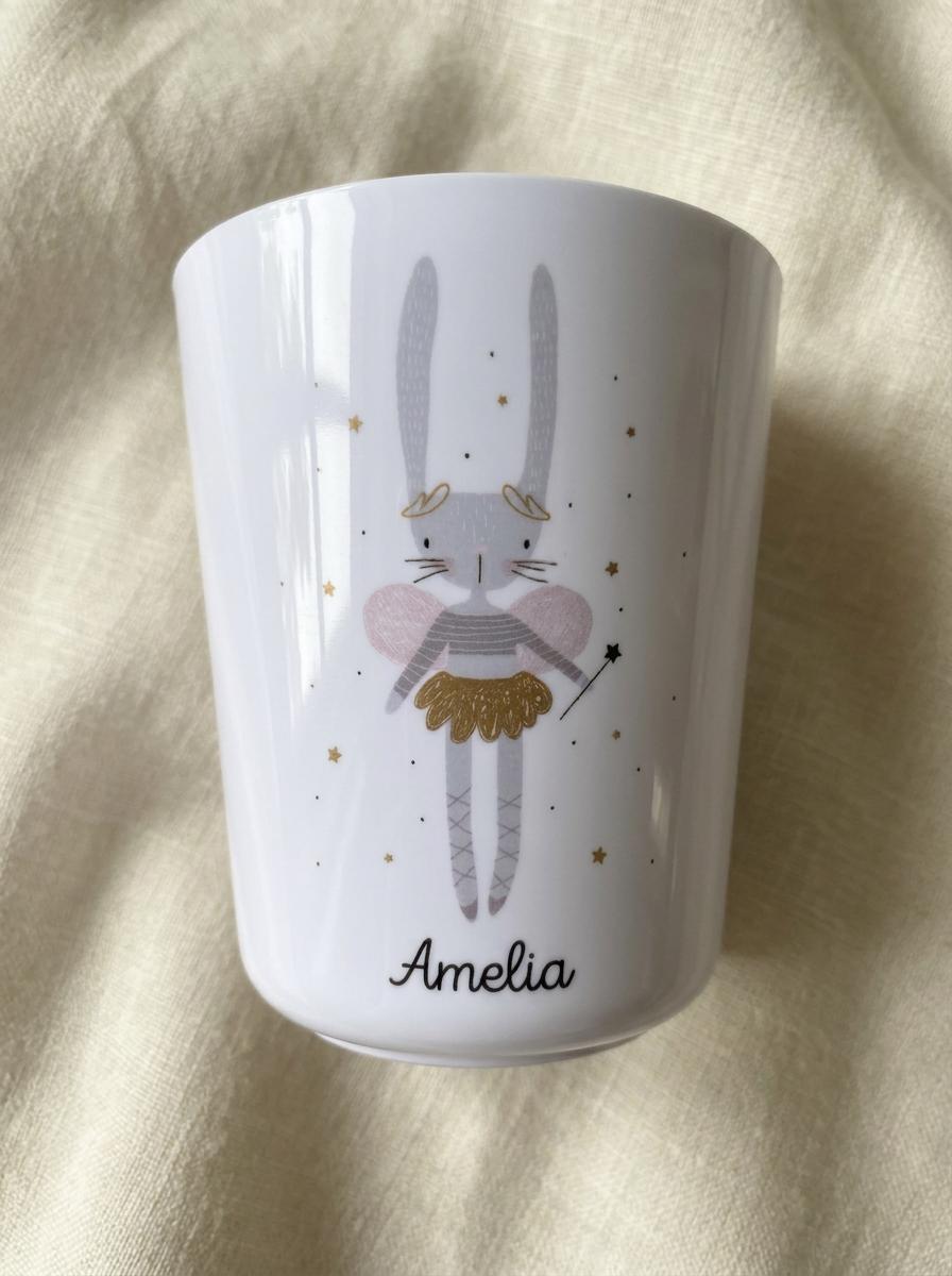 Close-up of the Bunny Ballerina cup design: a grey bunny in a pink tutu with gold sparkles holding a wand, with the name Amelia in script below.