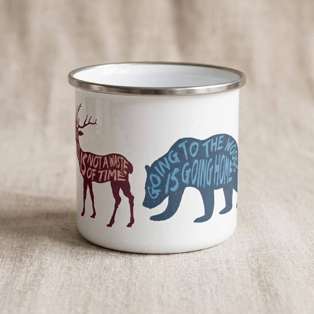 Woodland Animal enamel mug showing the burgundy deer silhouette and a blue bear silhouette lettered Going to the woods is going home.