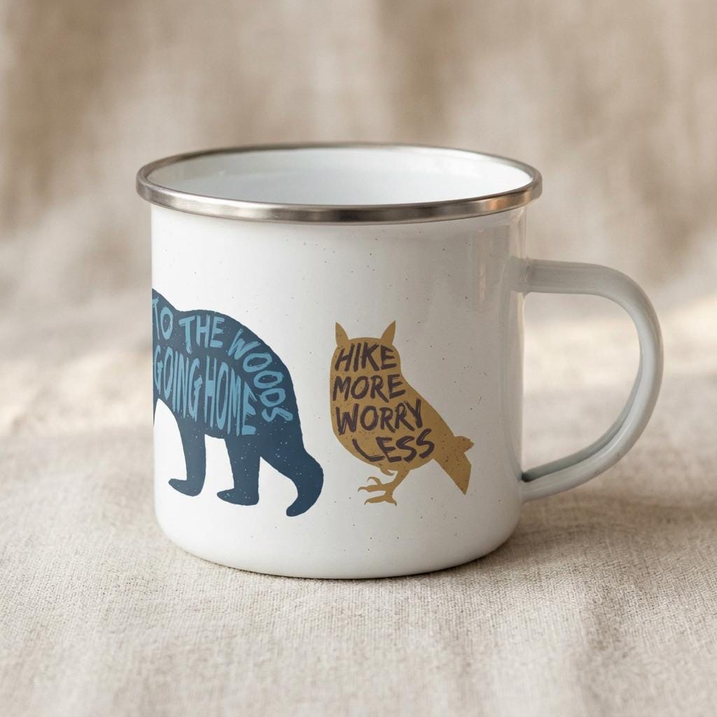 Woodland Animal enamel mug with the handle on the right, showing the blue bear silhouette and a mustard owl lettered Hike more, worry less.
