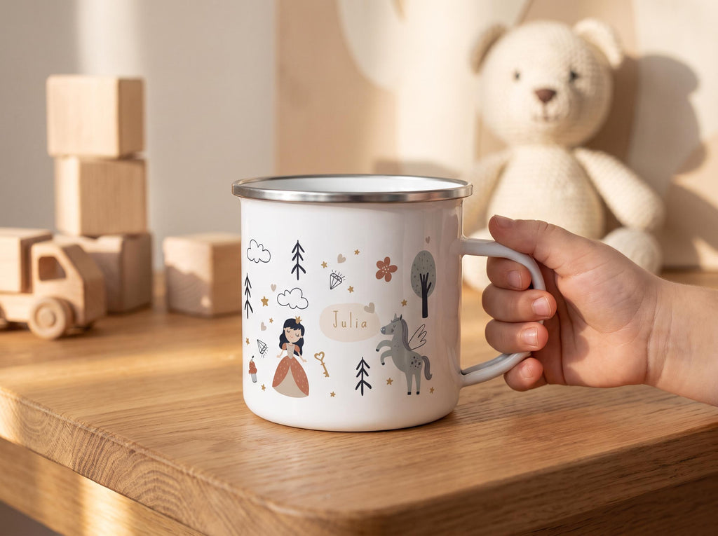 A white enamel mug with a silver rim featuring a printed design of a princess, a winged horse, trees, clouds, and a key. The name Julia is printed in the centre of the design. The mug has a handle on the right side.