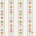 Wallpaper featuring a repeating vertical pattern of stylised flowers in shades of blue, pink, yellow, and green on an off-white background. The design includes thin dark green stripes separating the floral columns and a small b. logo.