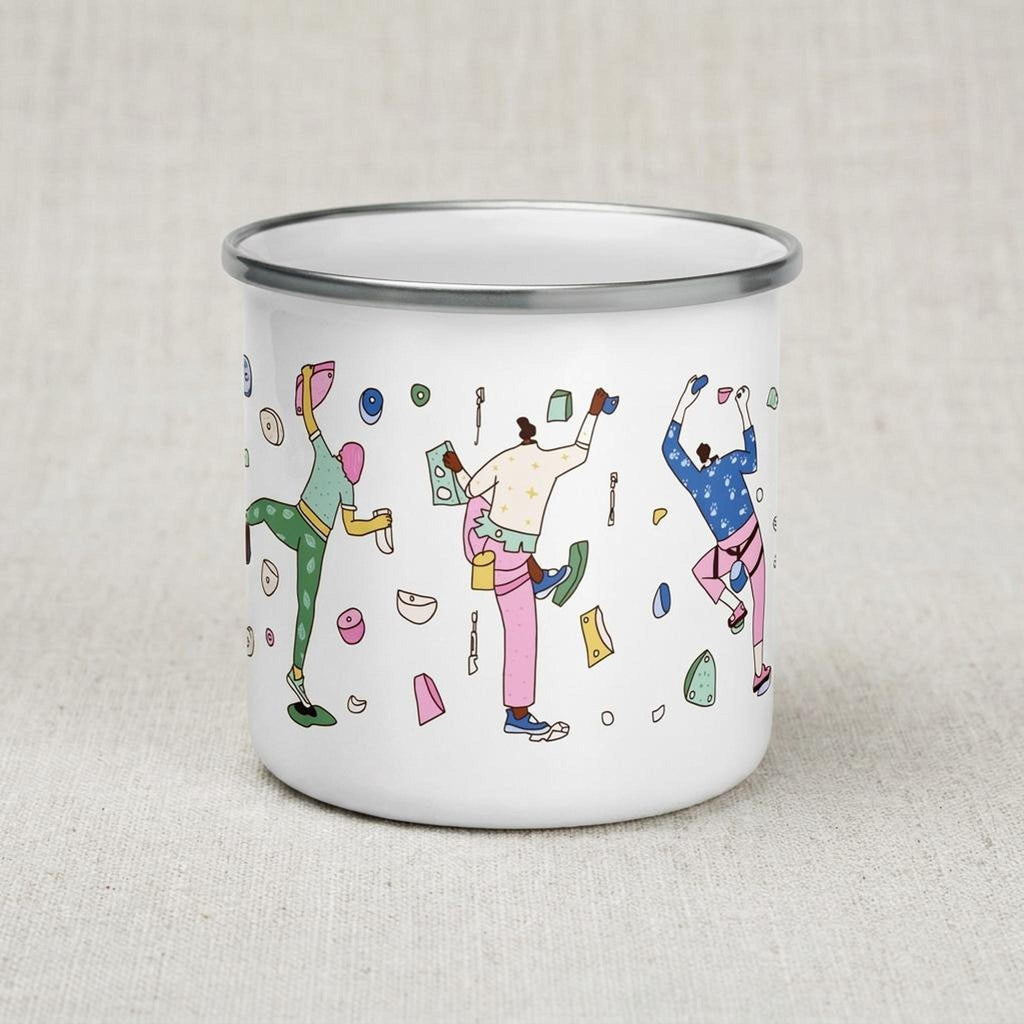 A white enamel camping mug displays multiple illustrated rock climbers.