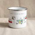 Front view of a white enamel camping mug featuring illustrations of campervans and the text HOME IS WHERE WE PARK IT.