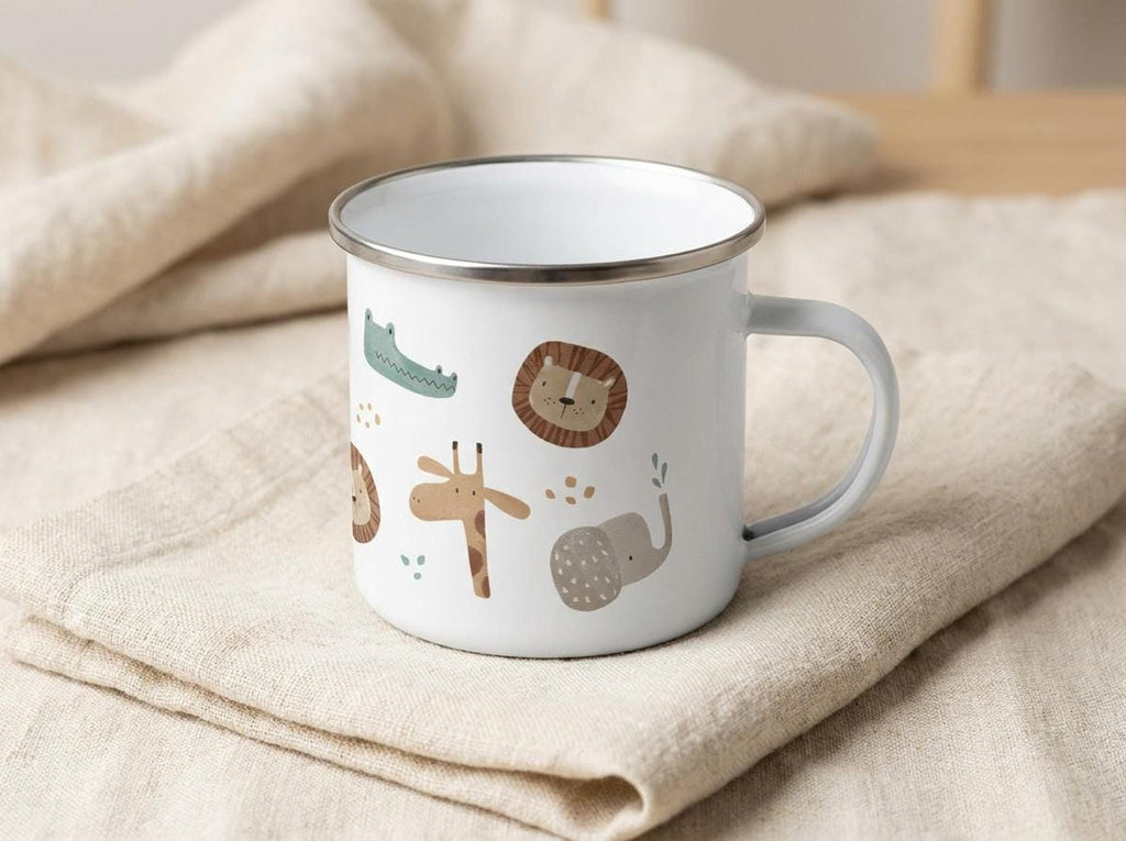 A white enamel mug featuring jungle animal drawings rests on folded light-colored cloth napkins.
