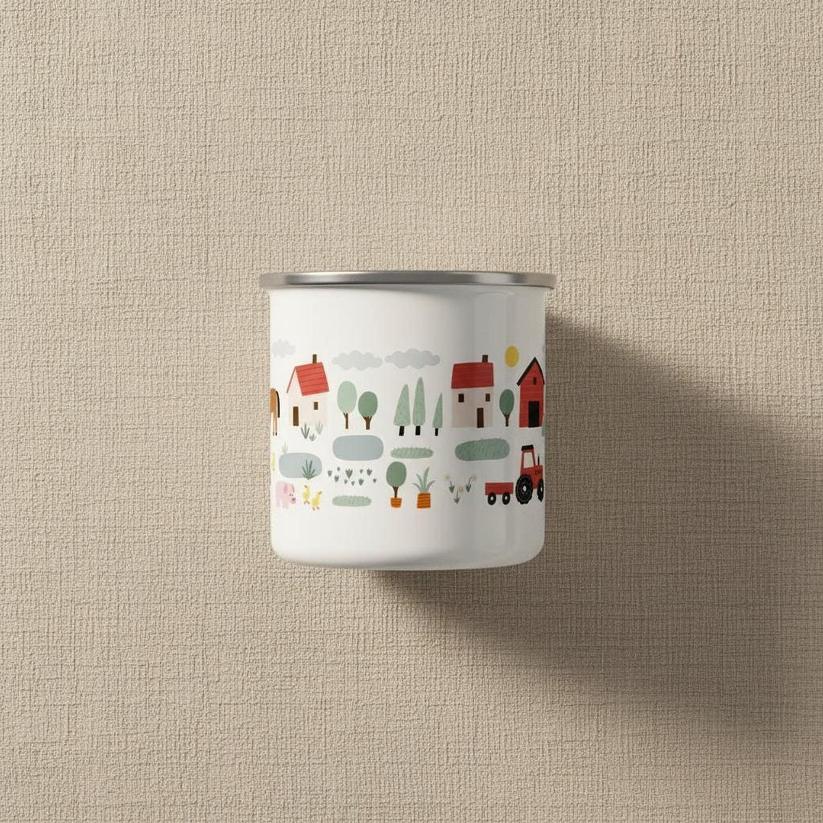 A white enamel mug featuring a continuous printed pattern of farm buildings, tractors, and animals against a textured background.