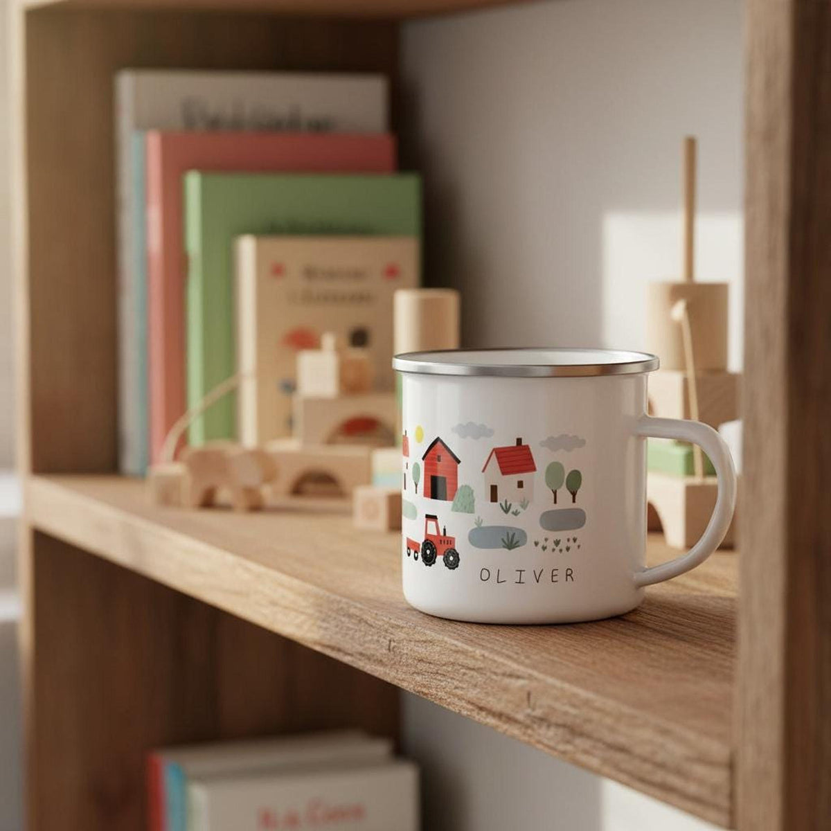 A personalised white enamel mug with red barns, a tractor, and the name OLIVER on a wooden shelf with wooden toys.