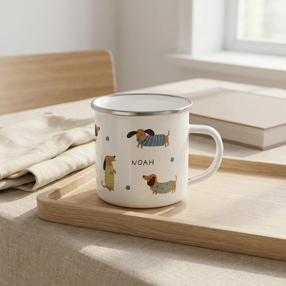 The white enamel mug resting on a wooden tray atop a table next to a folded napkin and a closed book.
