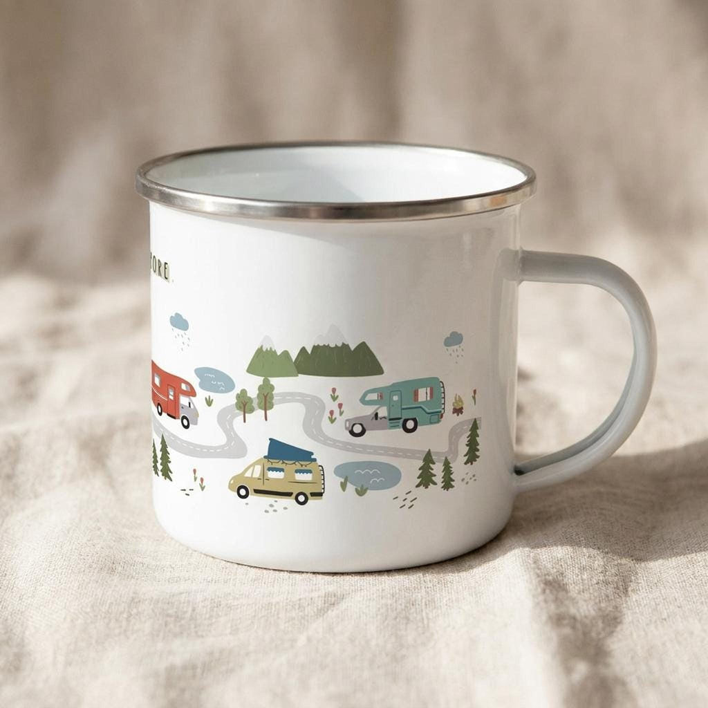 A different angle of the white enamel mug shows its handle on the right and more of the illustrated road scene featuring various camper vans and forest details.