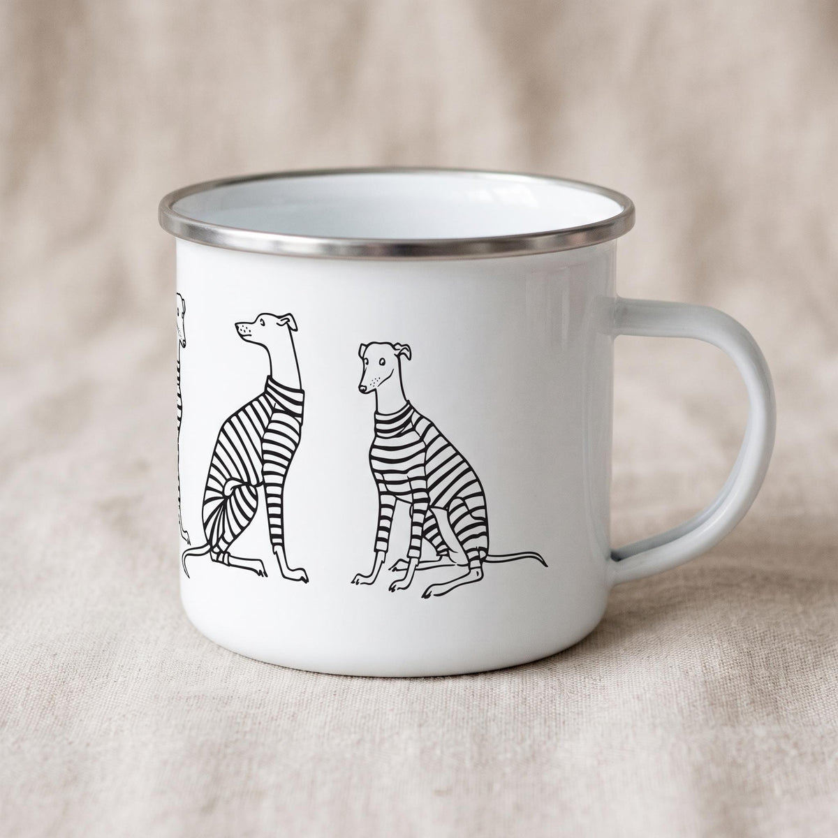 A white enamel mug with a silver-toned rim and a handle, featuring a black line art illustration of several greyhound dogs wearing striped sweaters. The dogs are depicted in various sitting and standing poses around the mug exterior.