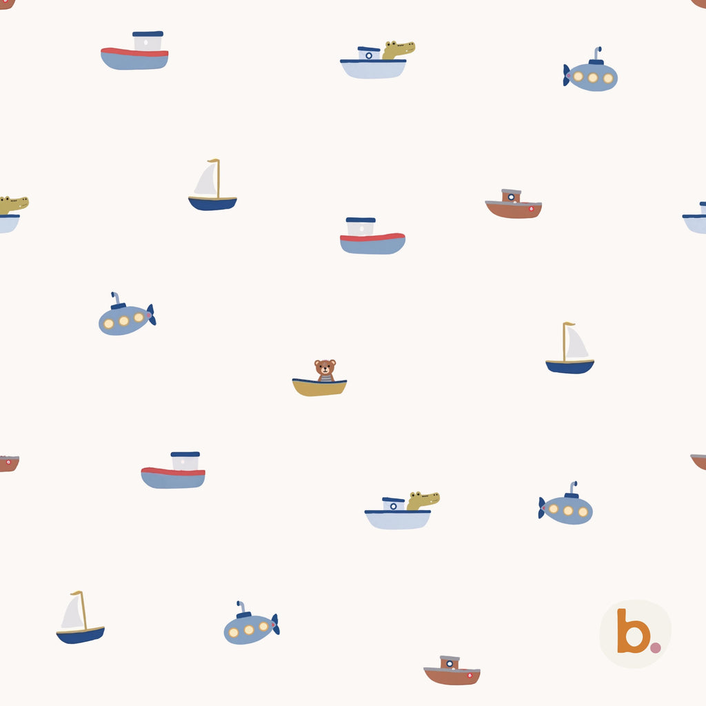 A repeating pattern on a cream background featuring various small boats, sailboats, and submarines in shades of blue, brown, and yellow. Some vessels contain small illustrated animals like a bear and a crocodile. A small logo with the letter b is in the corner.