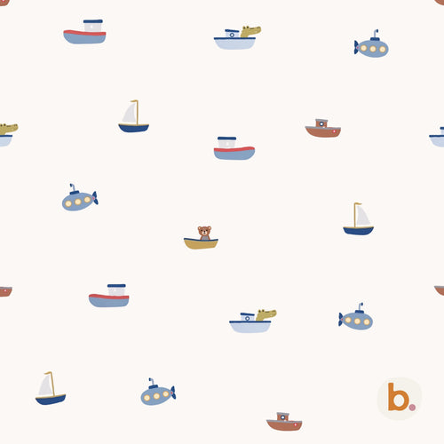 A repeating pattern on a cream background featuring various small boats, sailboats, and submarines in shades of blue, brown, and yellow. Some vessels contain small illustrated animals like a bear and a crocodile. A small logo with the letter b is in the corner.