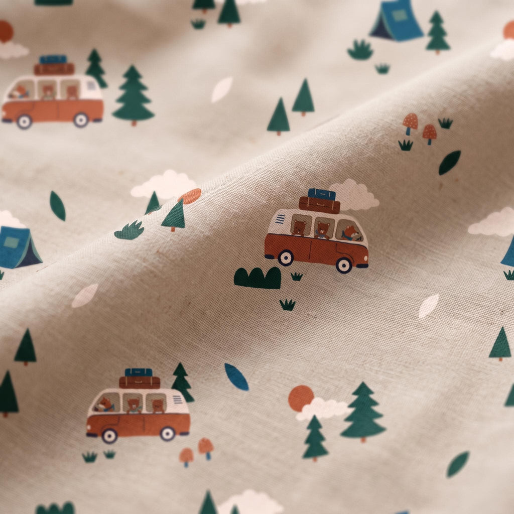 A light beige fabric featuring a repeating pattern of orange and white camper vans, green pine trees, blue tents, white clouds, small orange mushrooms, and brown bears visible through the windows of the vehicles in a camping scene.