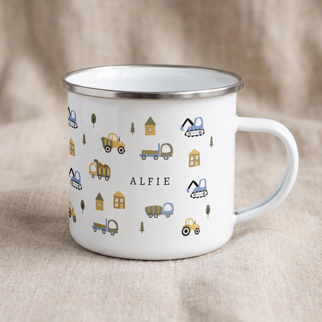 A white enamel mug with a silver rim displays a pattern of construction vehicles and trees with the name ALFIE printed in black on the side.