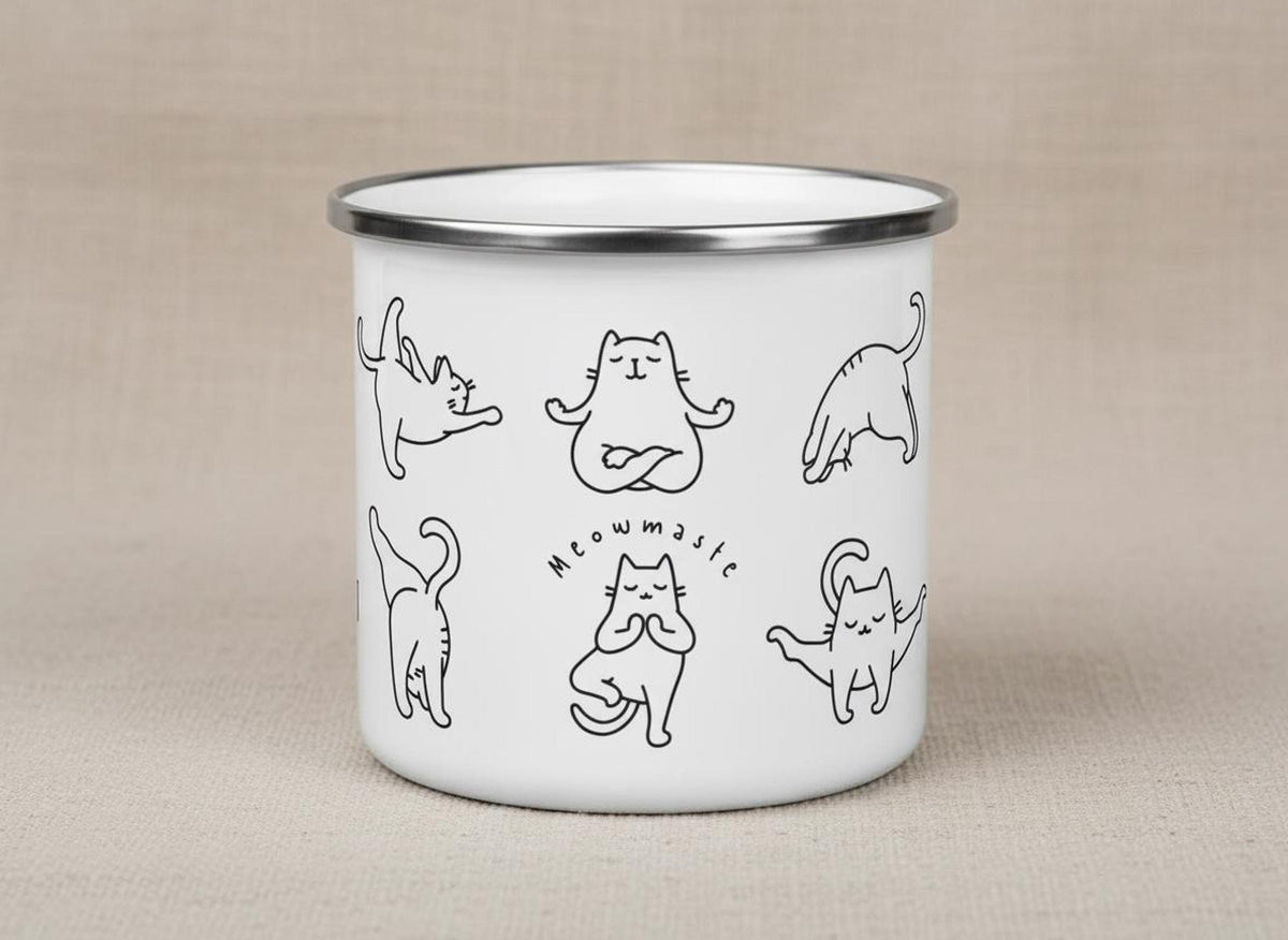 Studio product shot of the white enamel cat yoga mug standing upright on a neutral fabric surface.