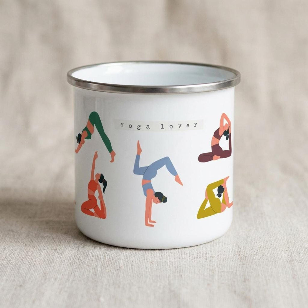 White enamel mug featuring illustrations of people in yoga poses and the text Yoga lover.