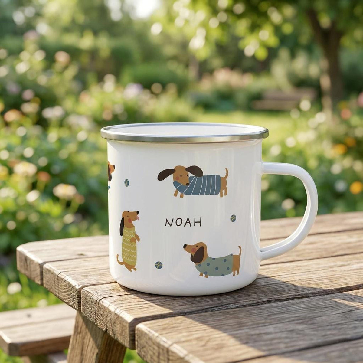The dachshund enamel mug sitting on a wooden picnic table outdoors with a blurry garden background.