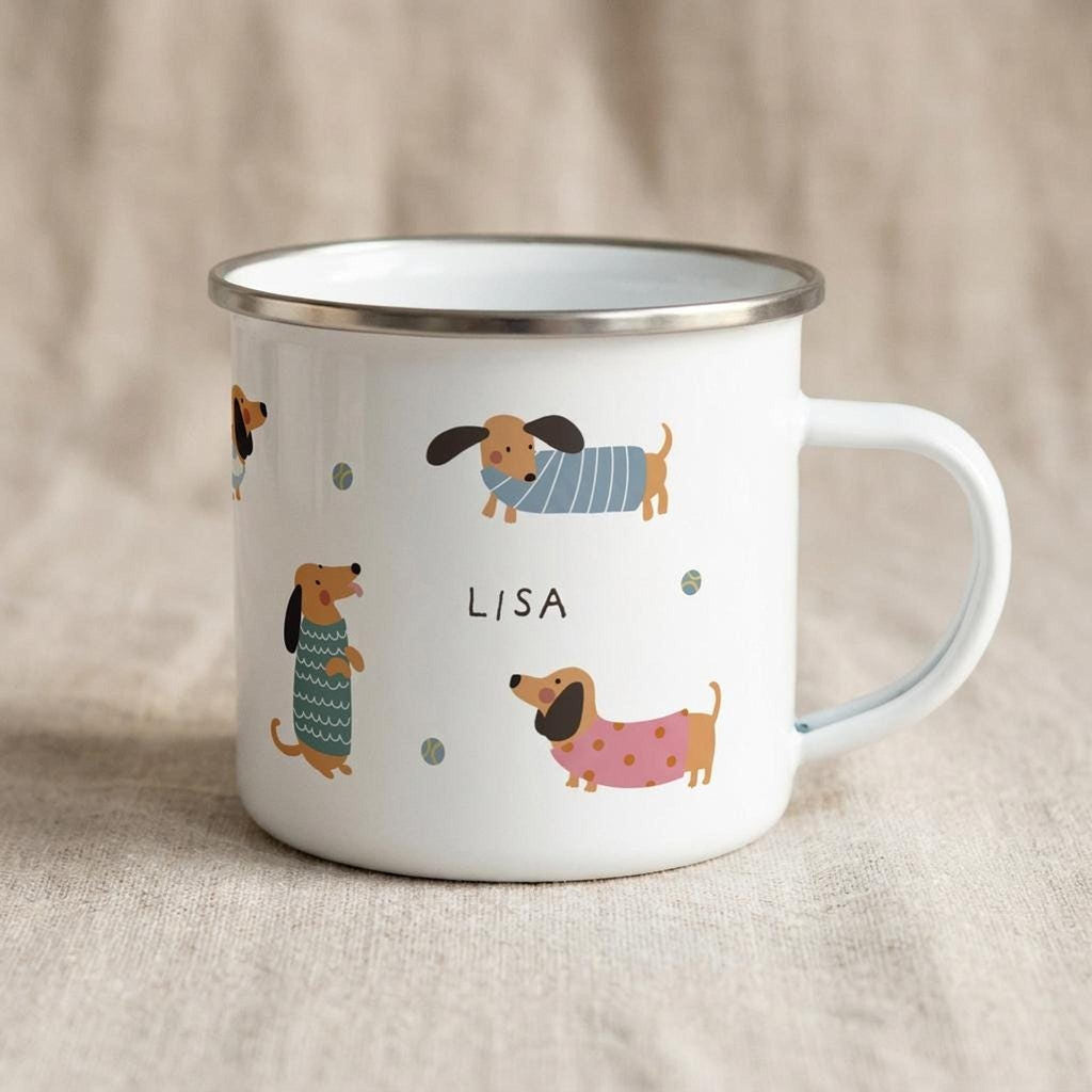 A white enamel mug with illustrations of dachshunds and the name Lisa on a linen surface.