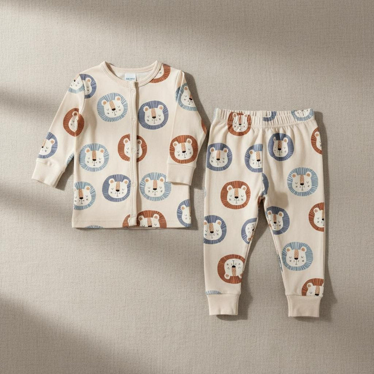 Matching long-sleeve button-down top and pants set for babies, printed with a playful lion pattern.