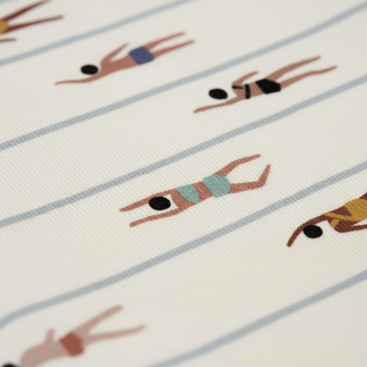 Detailed close-up showing the knit texture and swimmer motif of the patterned fabric.