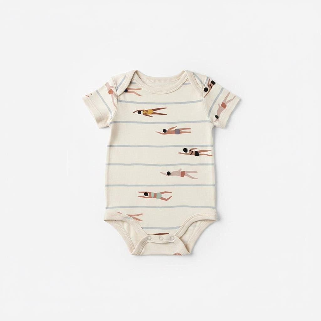 A baby onesie made from cream fabric printed with a repeating swimmer and stripe pattern.