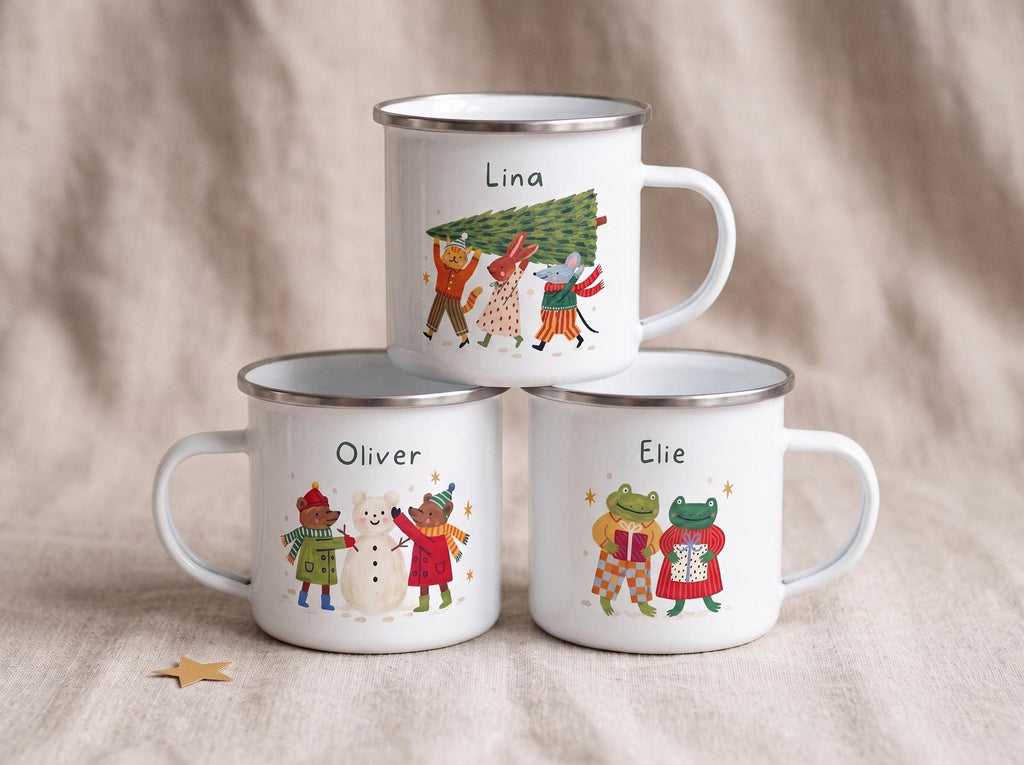 Three white enamel mugs with silver rims stacked on a textured surface, each personalized with a child's name and a different winter animal illustration.
