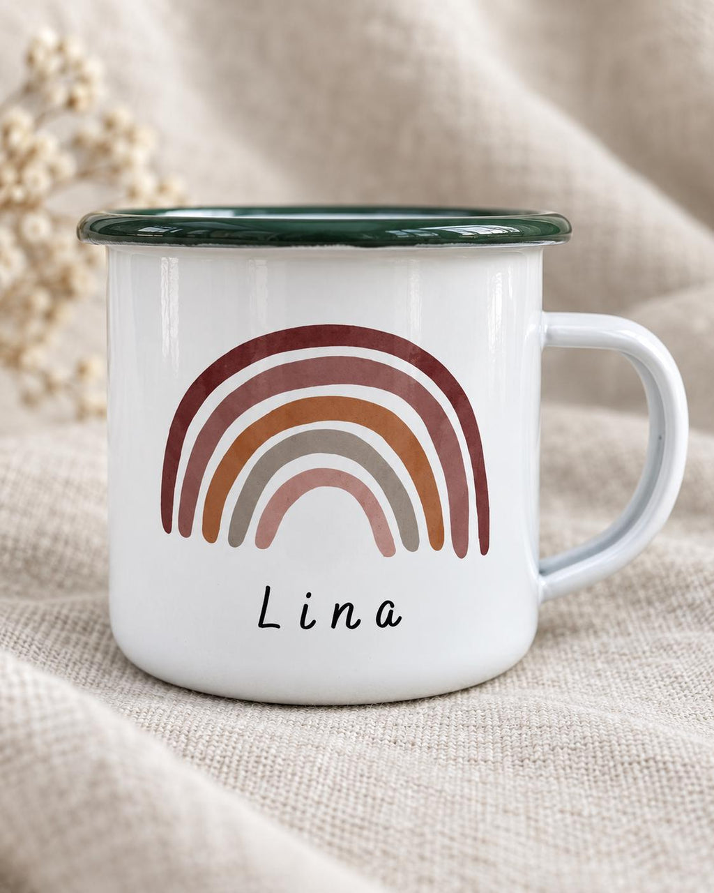 A white enamel mug featuring a dark green rim and a handle. The front of the mug displays a graphic of a multi-coloured rainbow in shades of terracotta, rust, and muted pink, with the name Lina printed in black text below the rainbow.