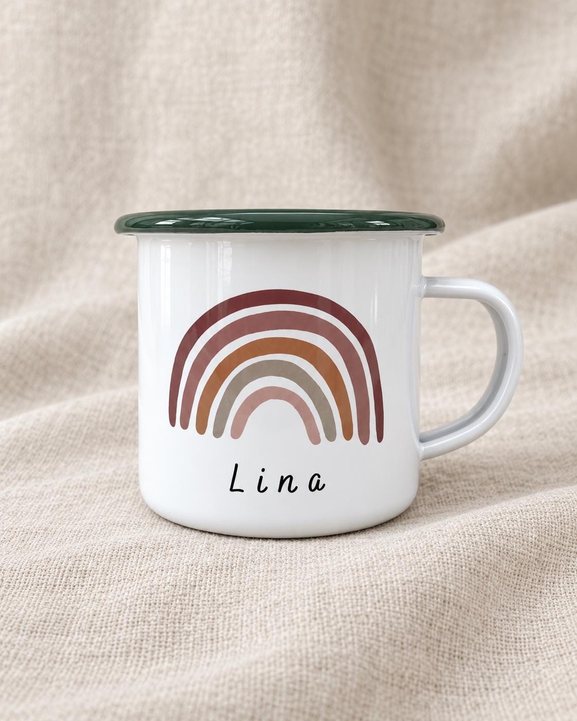A white enamel mug with a dark green rim and a handle on the right side. The front features a graphic of a multi-coloured rainbow in shades of terracotta, brown, and beige, with the name Lina printed in black text below the rainbow.