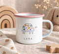 A white enamel mug with a pink rim and a handle, featuring a graphic of a turtle with a multi-coloured spotted shell and the name LARA printed in black capital letters below the turtle illustration on the front of the mug.