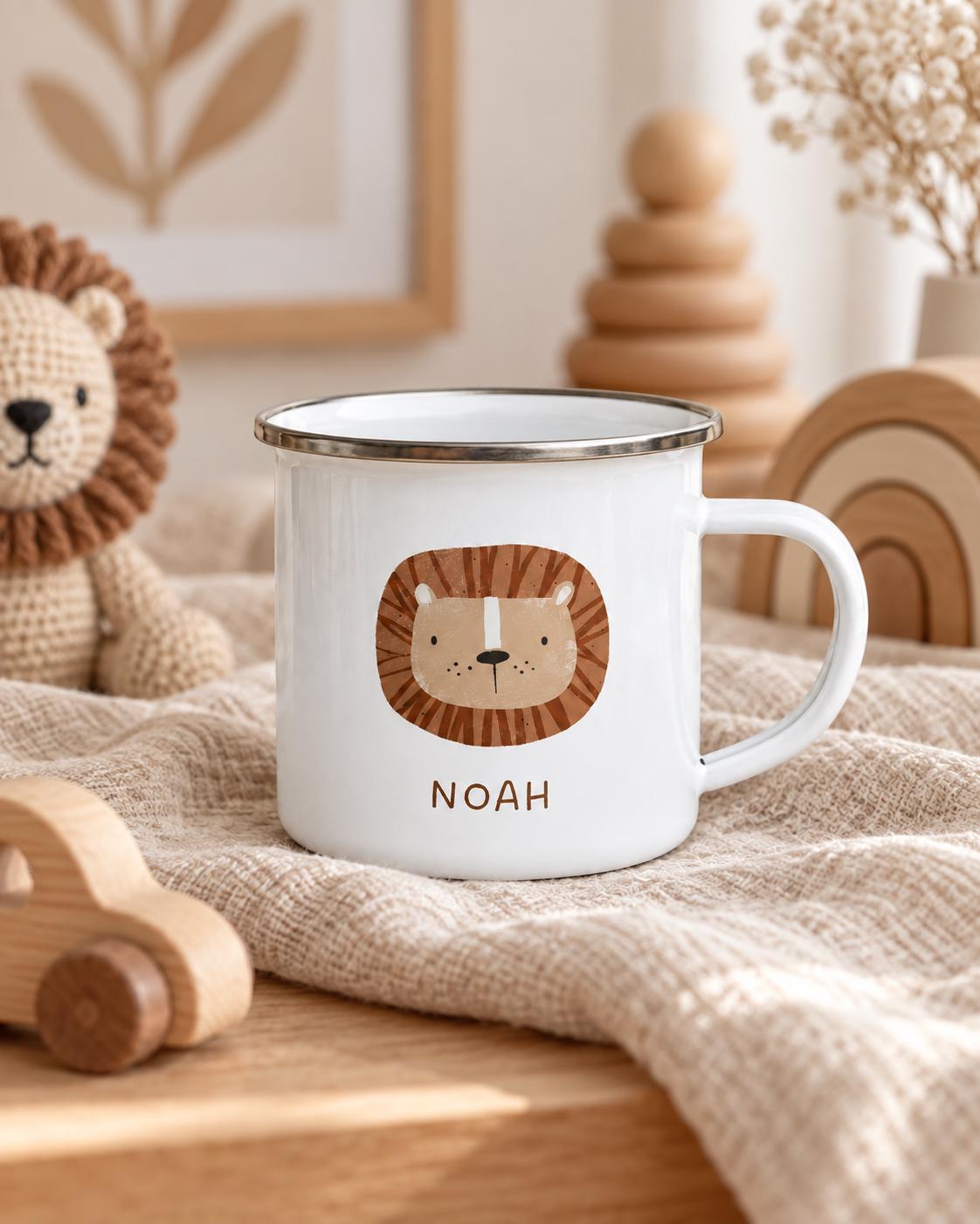A white enamel mug with a silver rim and a handle, featuring a brown and tan illustration of a lion's face centred on the front. Below the lion graphic, the name NOAH is printed in simple, dark brown capital letters.