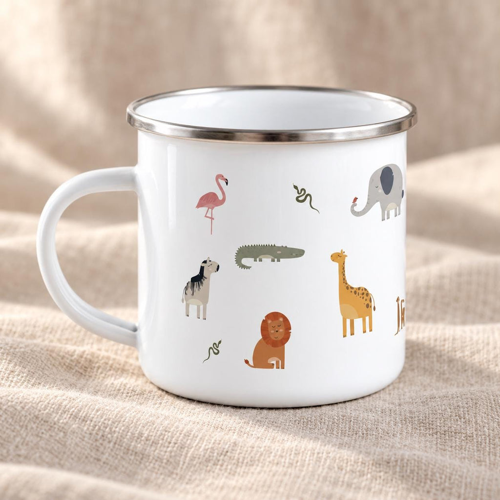 A white enamel mug with a silver rim and a handle, featuring a pattern of small, colourful illustrations of various animals including a pink flamingo, a green crocodile, a brown lion, a yellow giraffe, an elephant, and snakes.