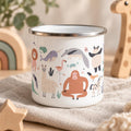 A white enamel mug with a silver-coloured rim featuring a colourful pattern of various animals including a panda, orangutan, llama, flamingo, narwhal, and anteater, along with small decorative elements like stars and butterflies.