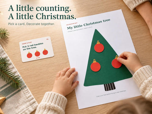 A child places the third red paper bauble on a green Christmas tree mat beside the matching counting challenge card.