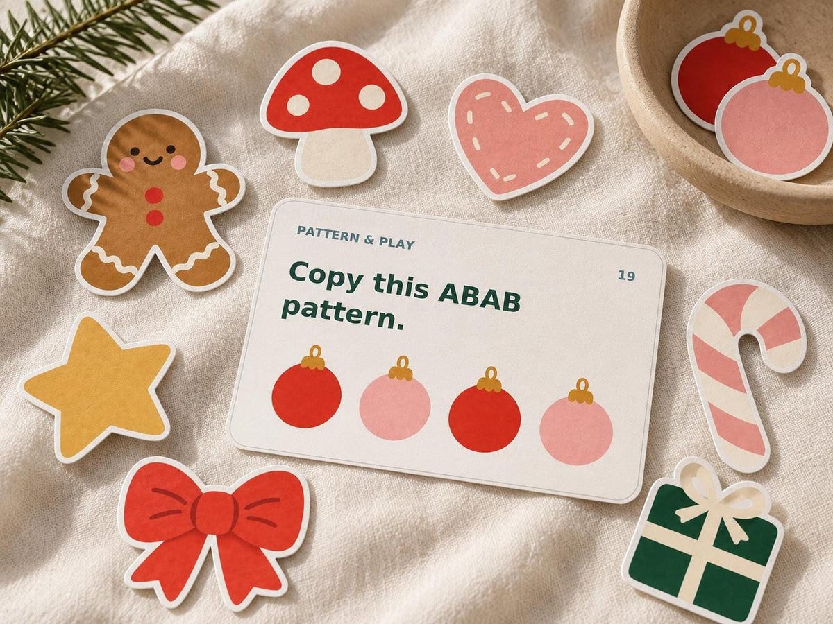 Close-up of Scandinavian Christmas paper decorations on linen surrounding an ABAB pattern card with red and pink baubles.