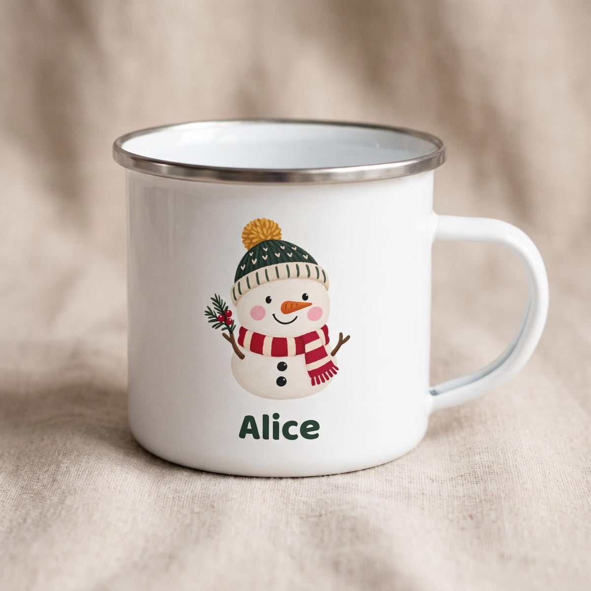 A white enamel mug with a silver metal rim features a snowman illustration with the name Alice.