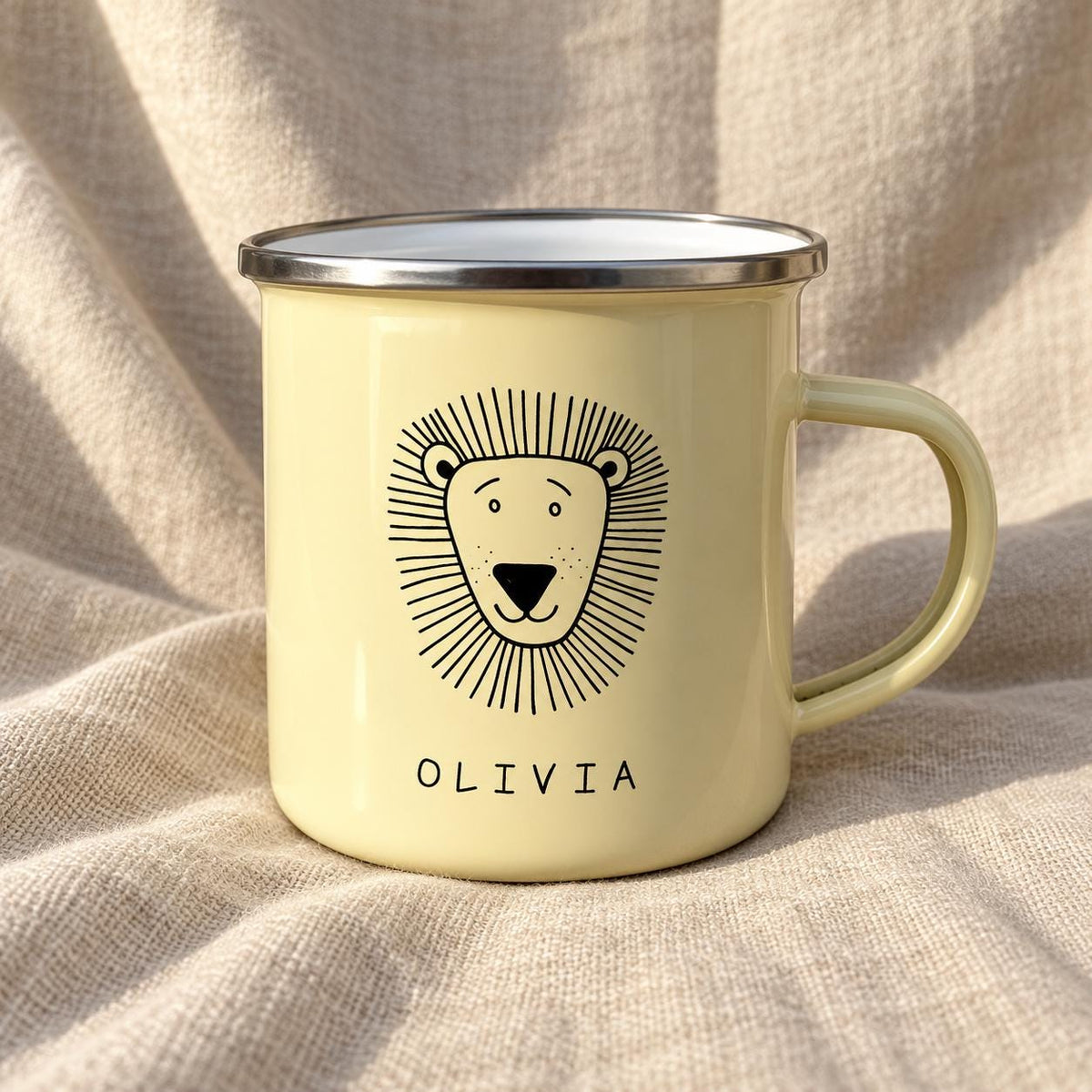 A pale yellow enamel mug featuring a black line drawing of a lion's face centred on the front. Below the lion illustration, the name OLIVIA is printed in black capital letters. The mug has a silver-coloured metal rim and a handle.