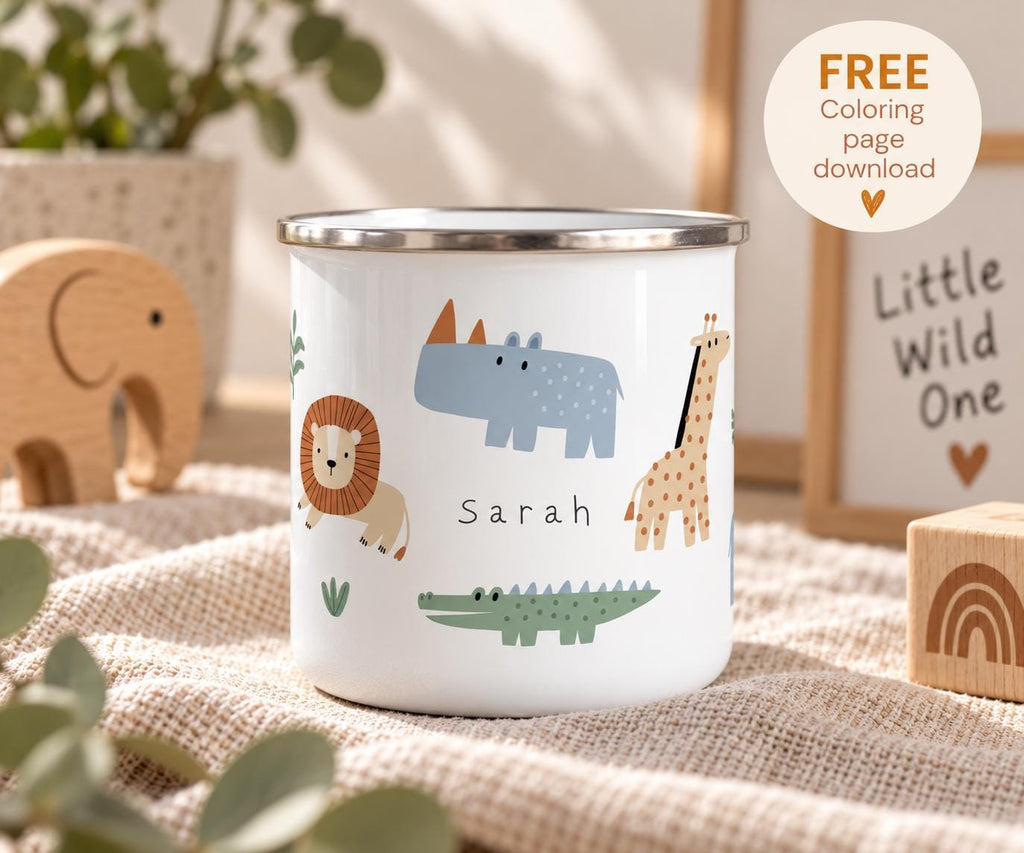 A white enamel mug with a silver rim featuring a colourful safari animal pattern including a lion, rhinoceros, giraffe, and crocodile. The name Sarah is printed in black text in the centre. A circular badge reads FREE Coloring page download.