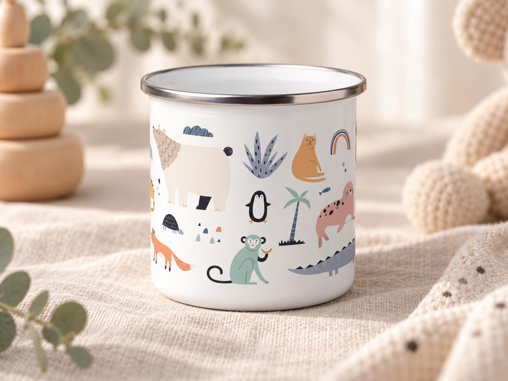A white enamel mug with a silver-toned rim featuring a colourful pattern of various animals including a bear, monkey, fox, penguin, and seal, along with small botanical elements like palm trees and a rainbow graphic printed on the exterior.
